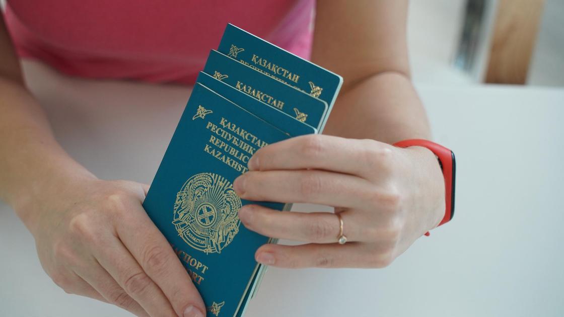 Женщина держит паспорта Казахстана в руках