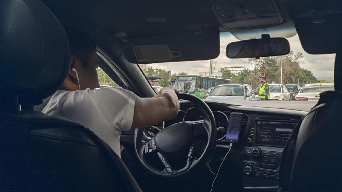 парень в наушниках сидит за рулем машины