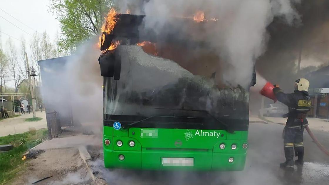 Пожарный тушит горящий автобус