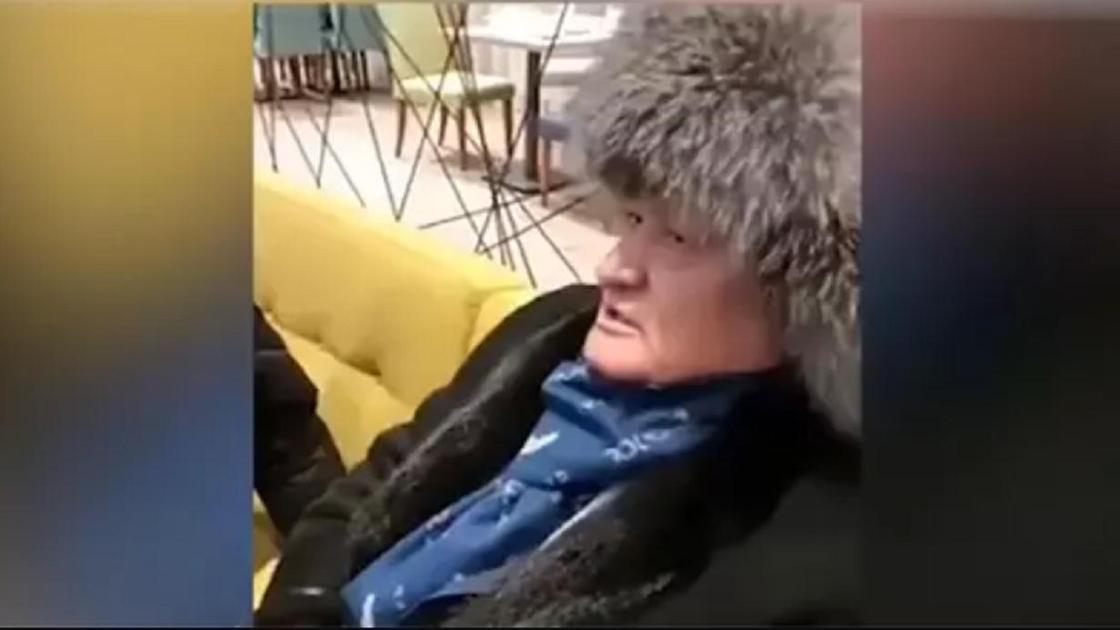 Мужчина в шапке сидит на диване