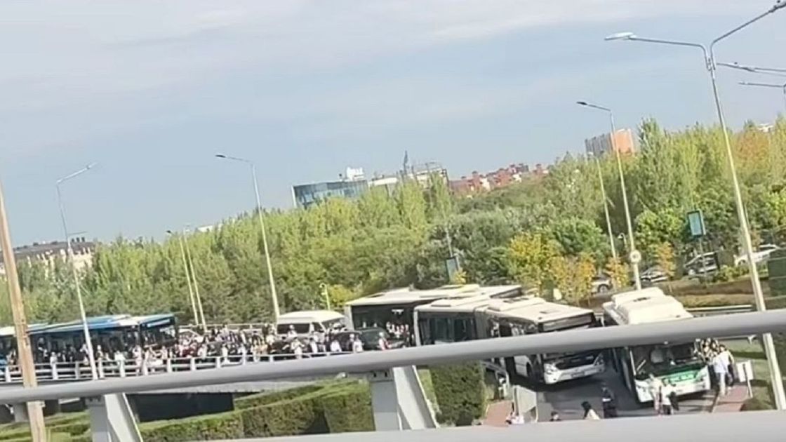 Люди идут по мосту в Астане
