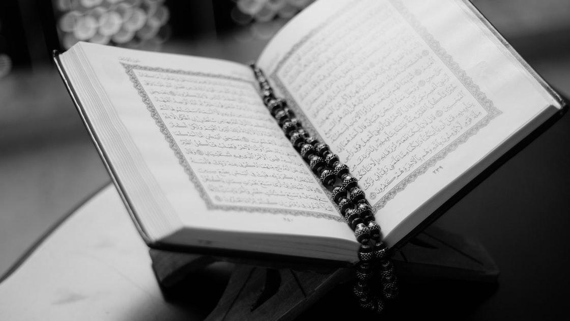 Раскрытый Коран и четки