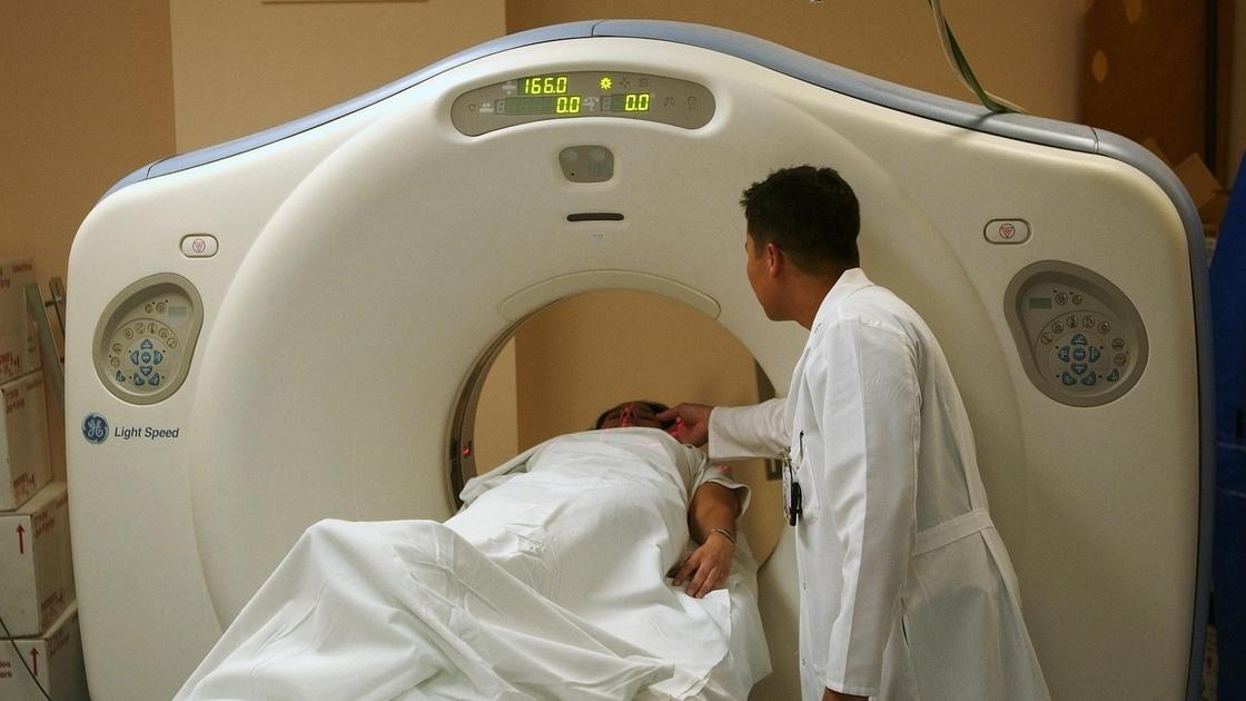 Врач готовит пациента к компьютерной томографии