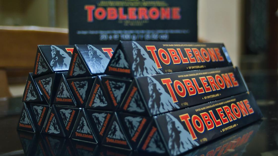 Упаковки шоколада Toblerone стоят на столе Упаковки шоколада Toblerone стоят на столе