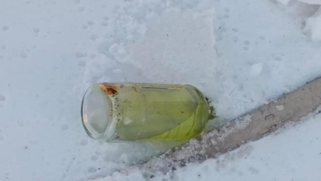 Бутылка с бензином лежит на земле