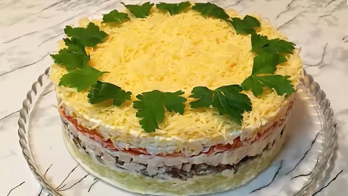 Салат «Королевский» с курицей на тарелке на столе Салат «Королевский» с курицей на тарелке на столе