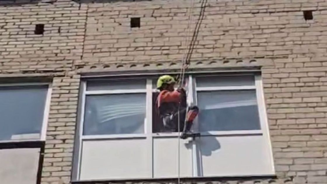 Спасатель спускается в квартиру с крыши