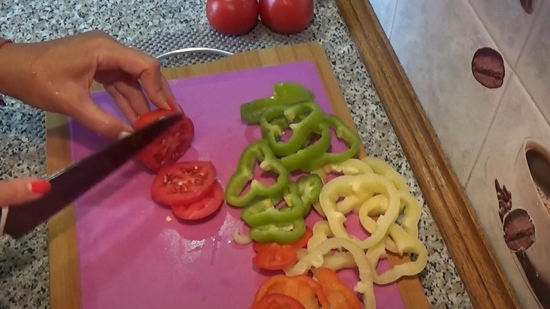 Ножом нарезают томаты и сладкий перец кольцами