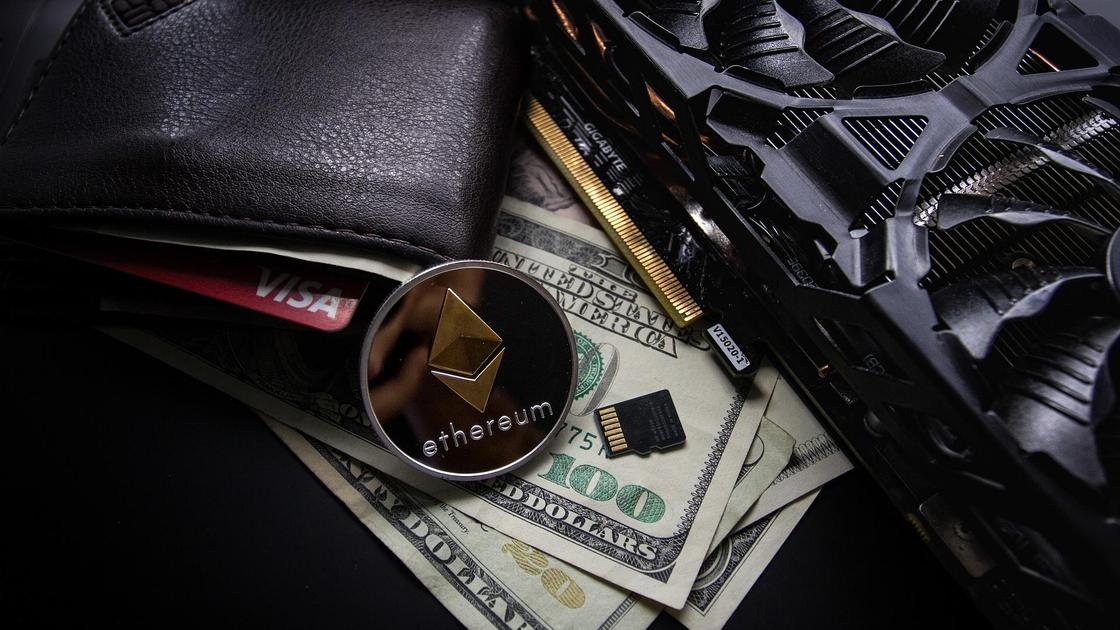 Монета Ethereum лежит на долларовых купюрах и кошельке