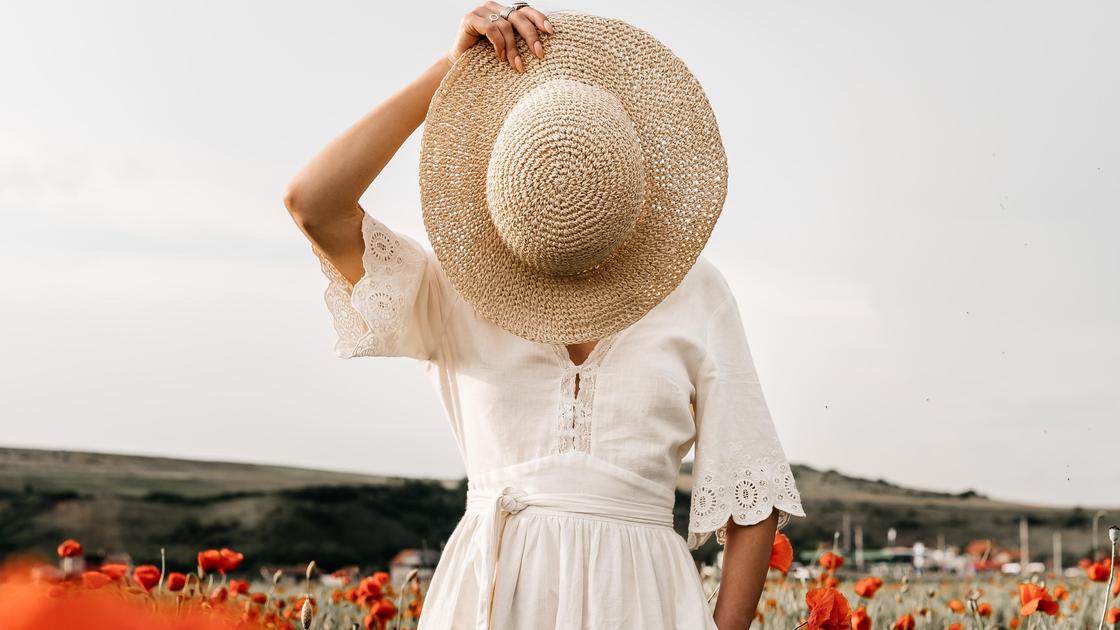 Девушка в белом платье и с шляпкой в руках