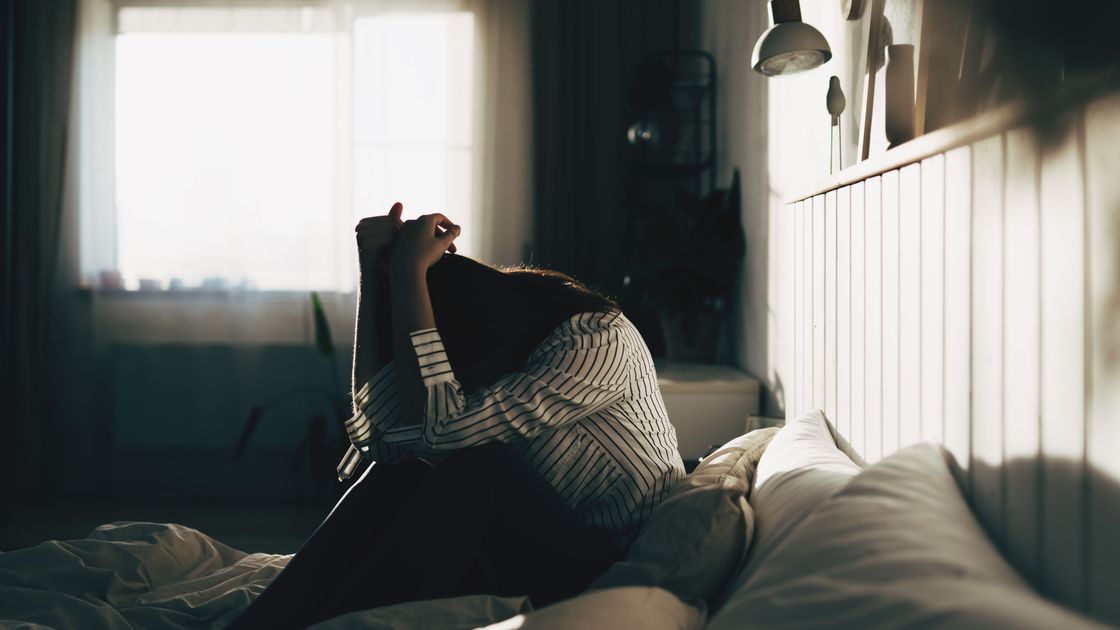 Женщина сидит на кровати