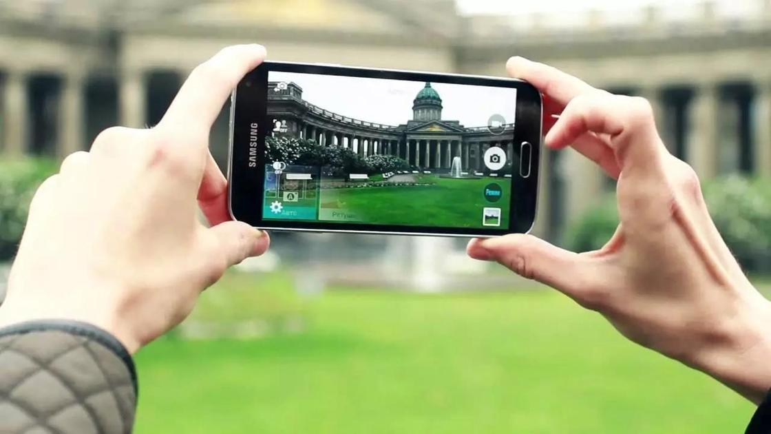 человек фотографирует здание на телефон человек фотографирует здание на телефон