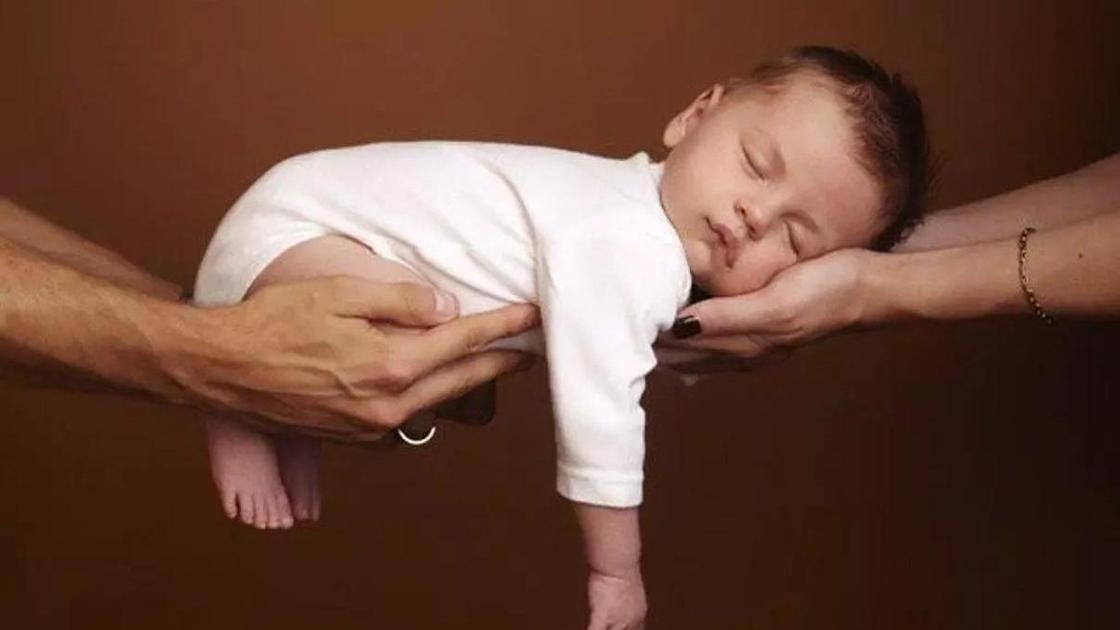 маленький ребенок на руках у родителей маленький ребенок на руках у родителей
