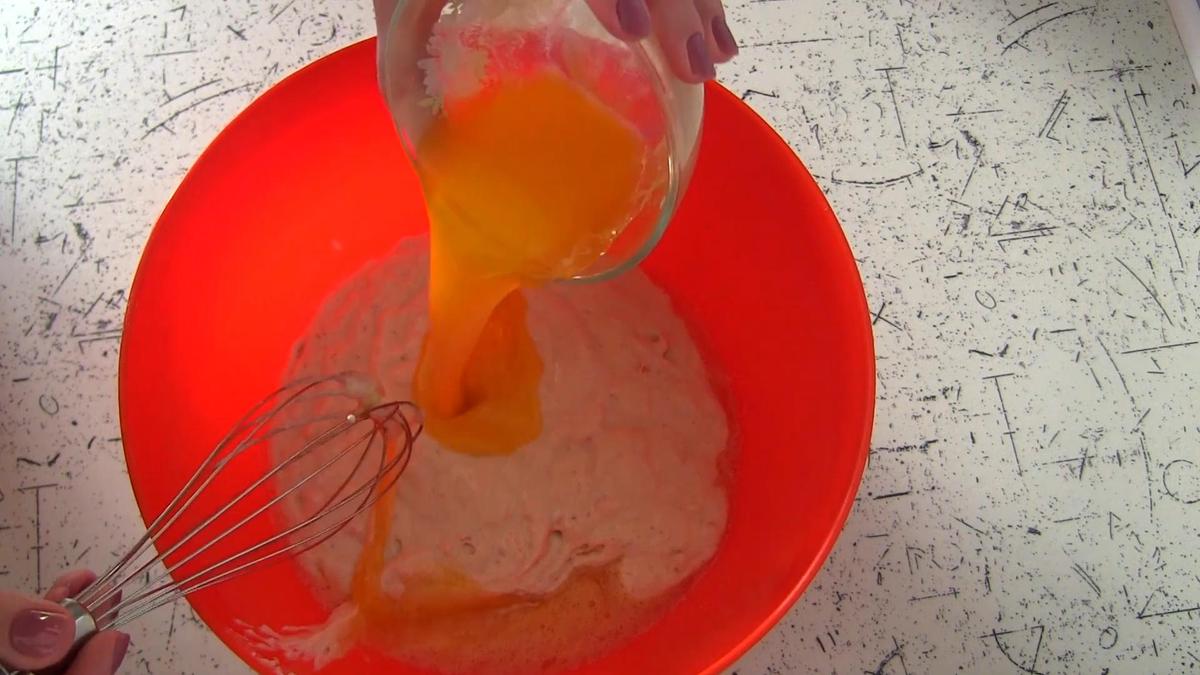 Добавление топленого молока в тесто в пластиковой миске