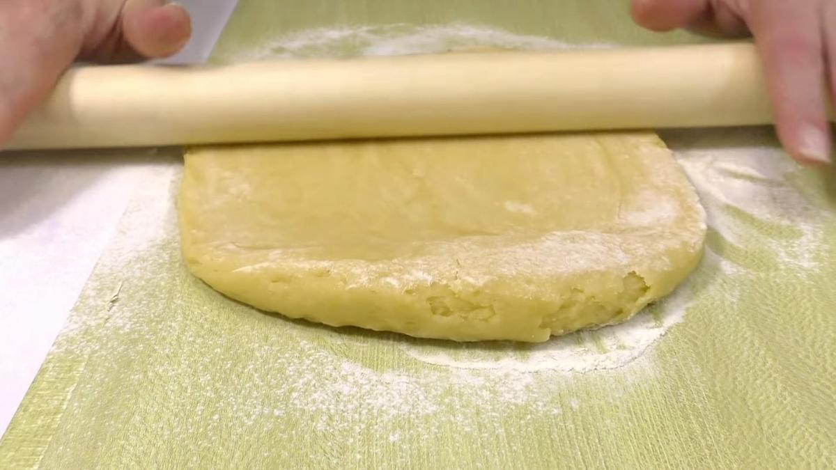 Раскатка теста скалкой на поверхности стола