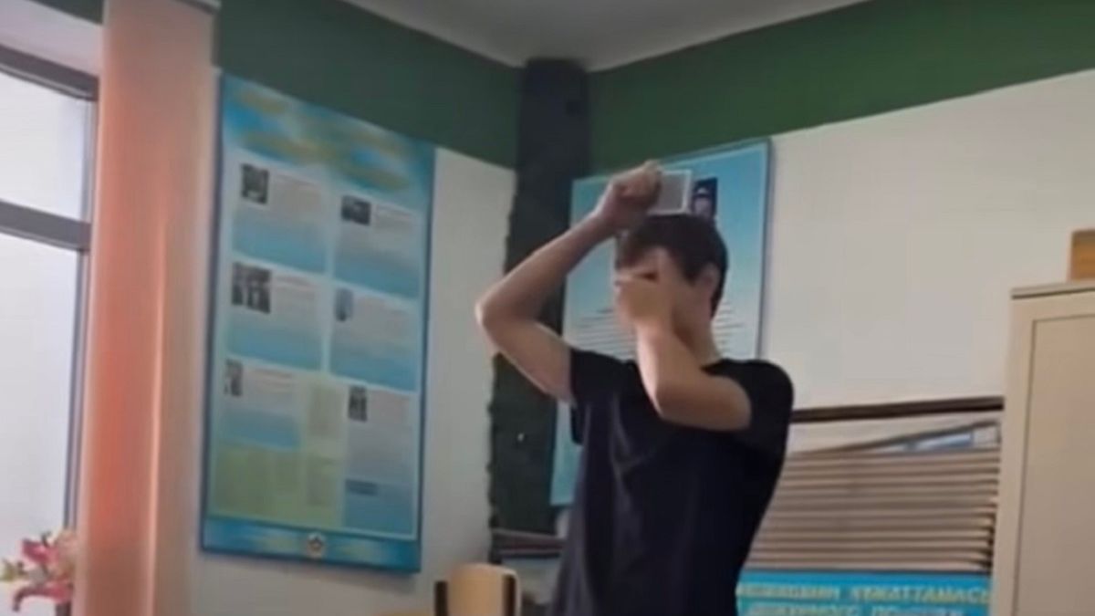 Студент держит над головой мишень