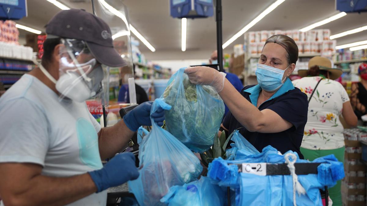 Муужчина в маске покупает продукты