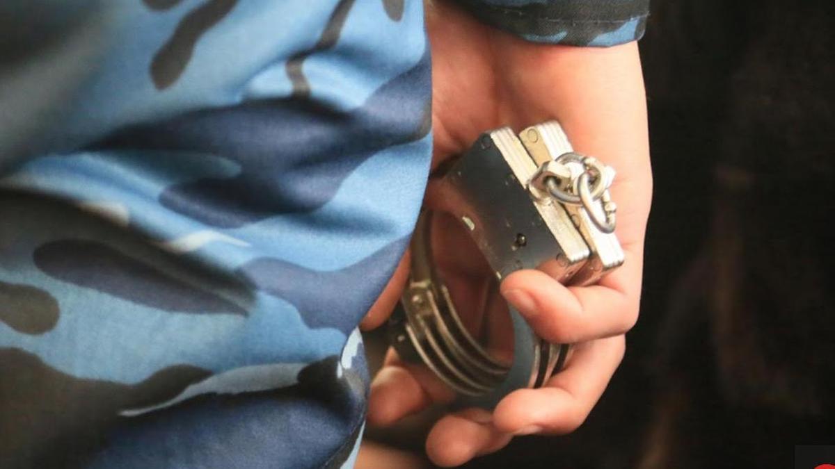 кісен ұстап тұрған полицей