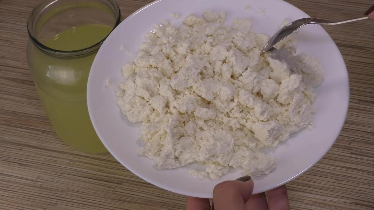 Тарелка творога рядом с банкой с сывороткой