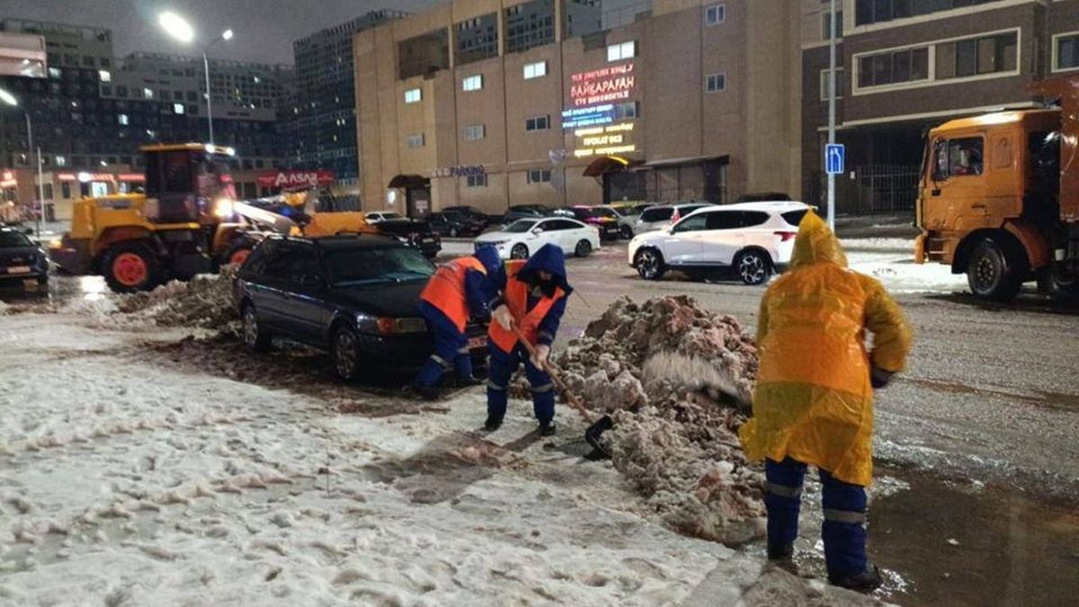Жолды тазартып жатқан жұмысшылар