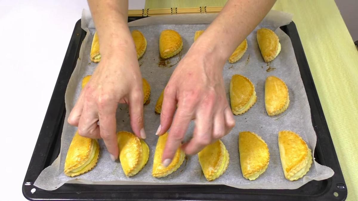 Женские руки снимают выпечку с противня
