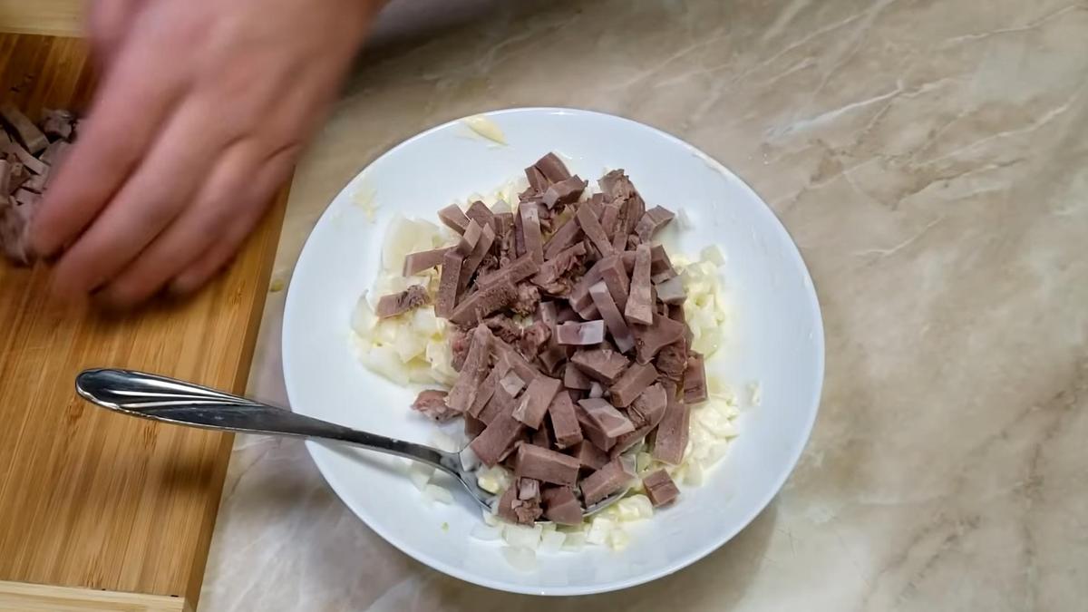 Нарезанный язык и лук в глубокой тарелке