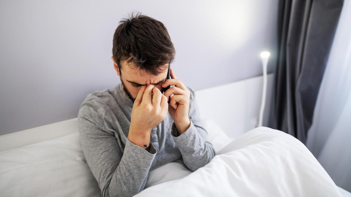 Мужчина отвечает на звонок в постели