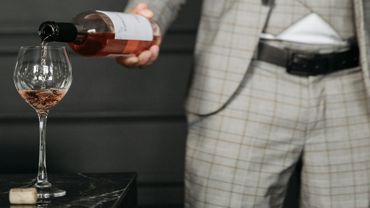 Мужчина наливает вино