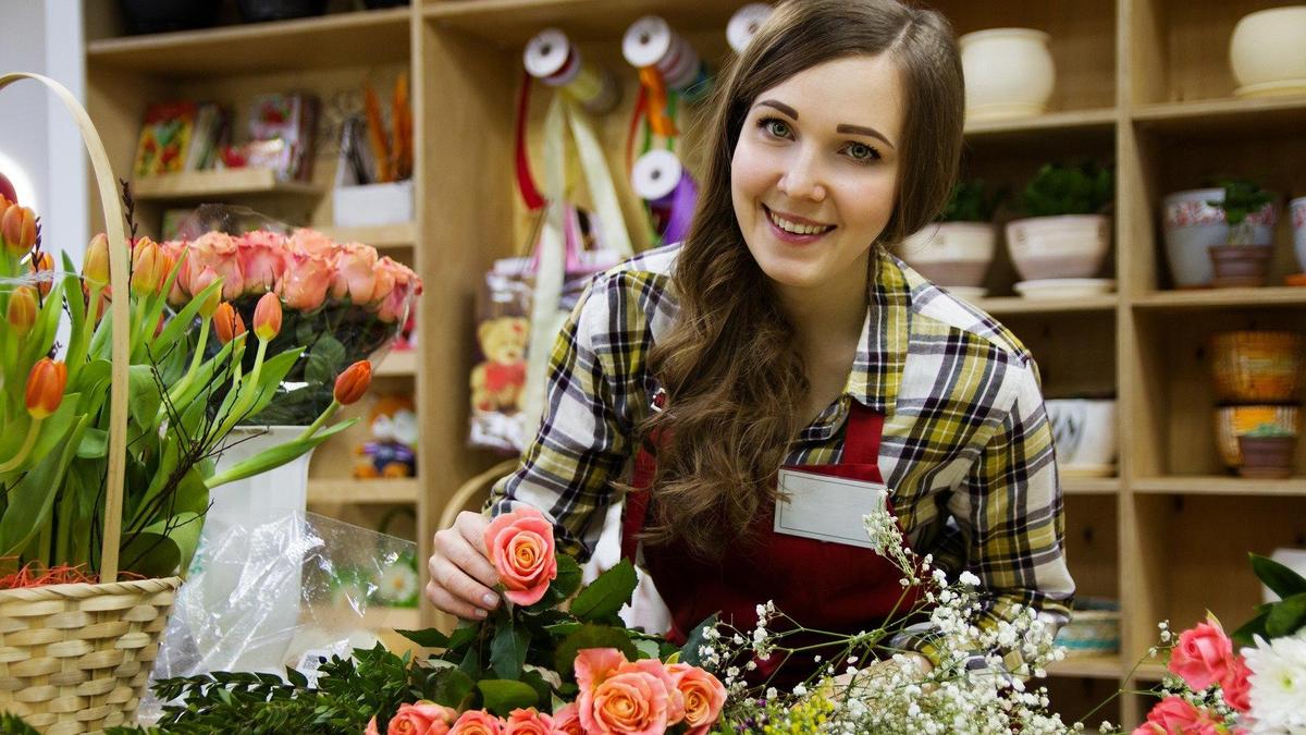 Девушка стоит возле цветов