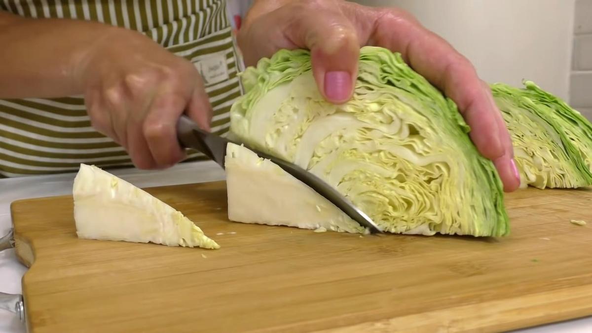 На разделочной доске нарезают белокочанную капусту