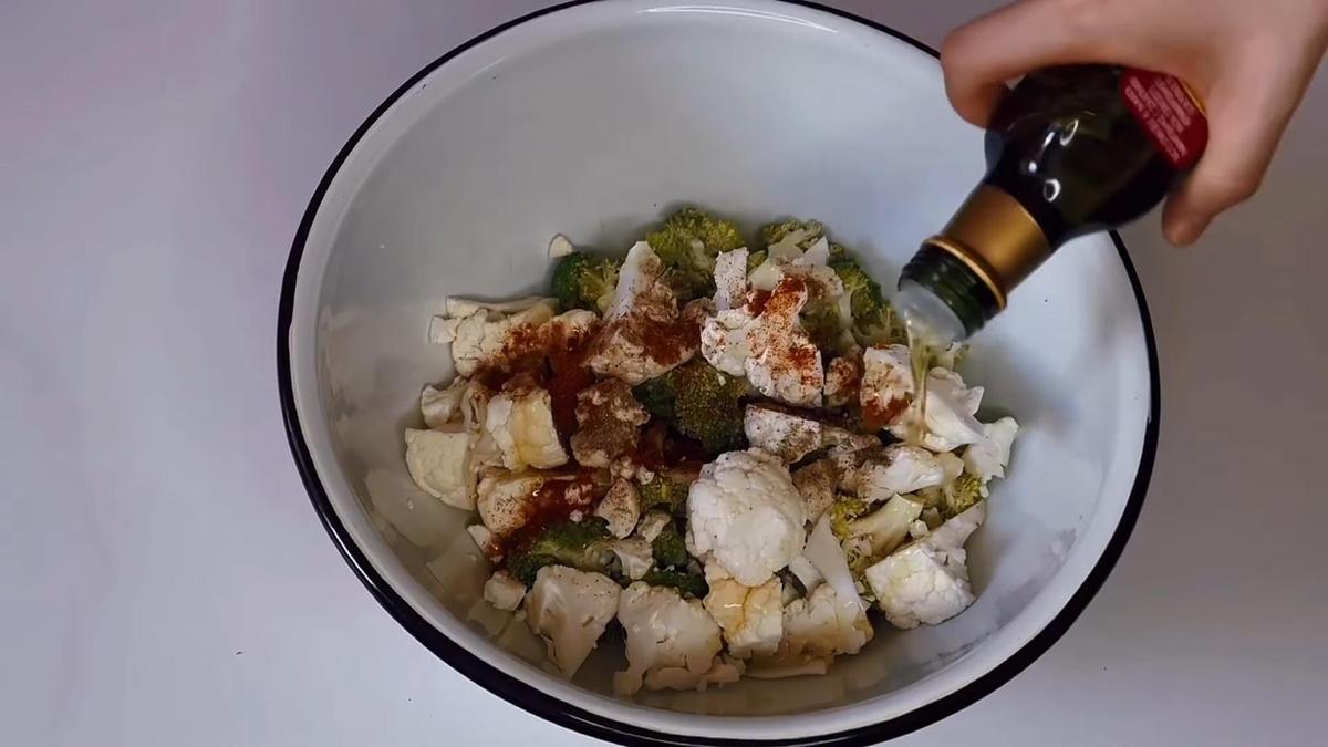 В емкость с двумя видами капусты добавляют оливковое масло и специи