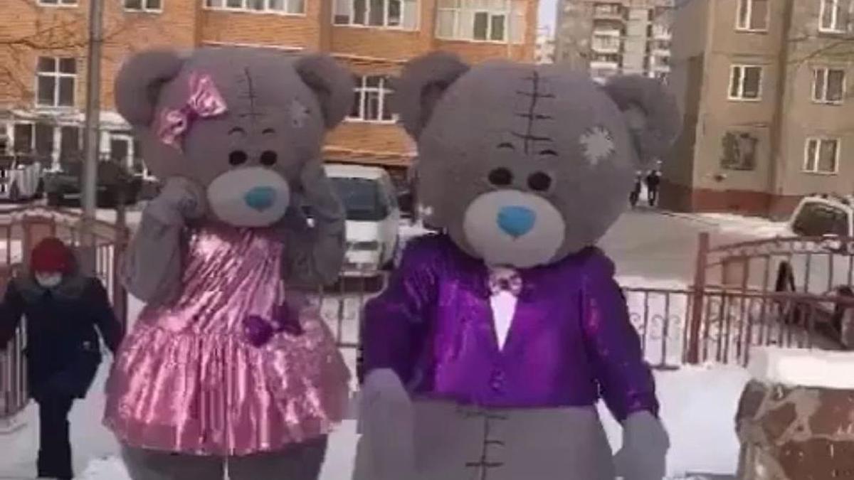 Люди в костюмах мишек Тедди идут по улице Люди в костюмах мишек Тедди идут по улице