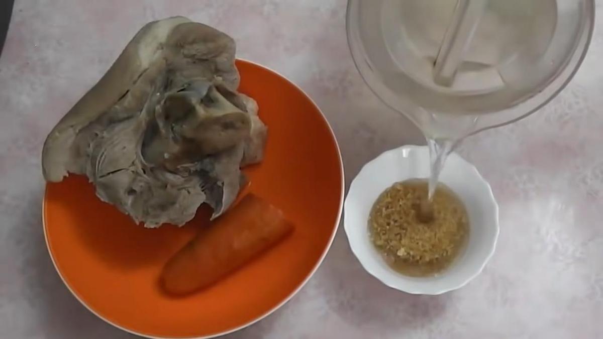 Тарелка с мясом и морковью. Рядом блюдце с желатином, в который наливают воду