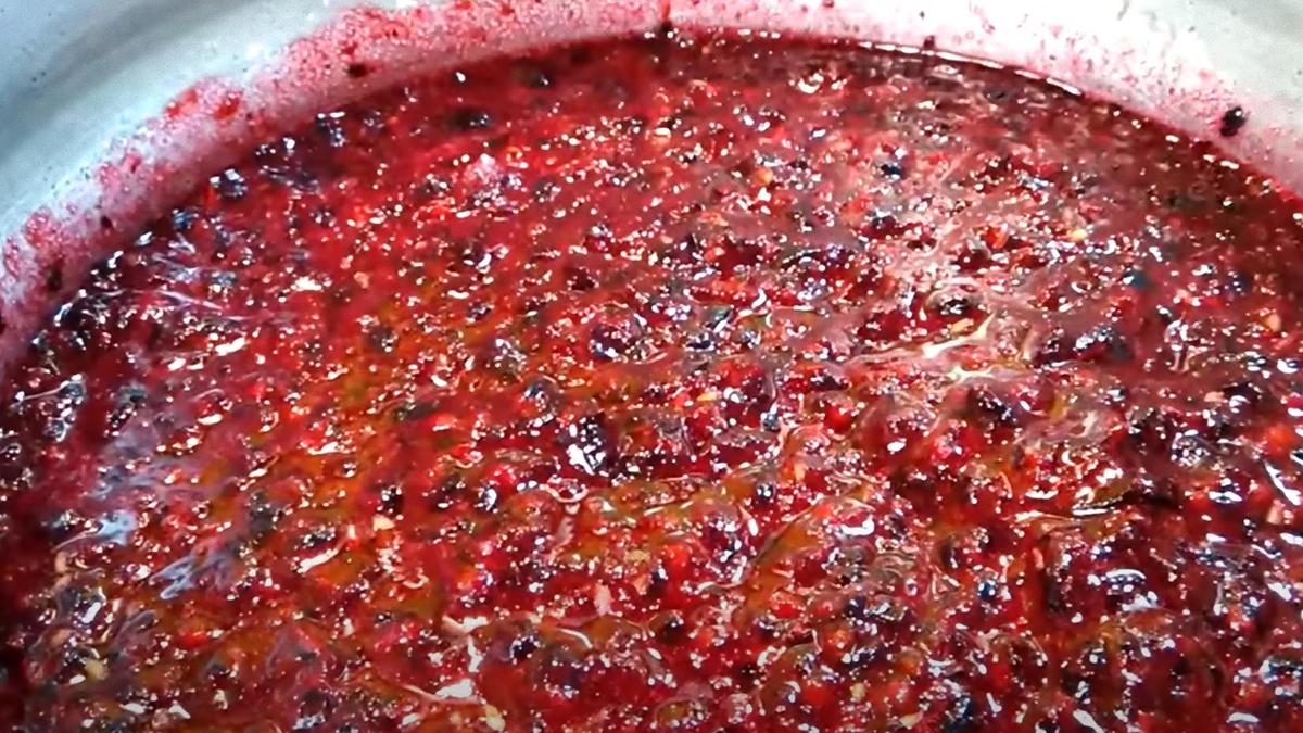 Перетертая смородина варится в тазике