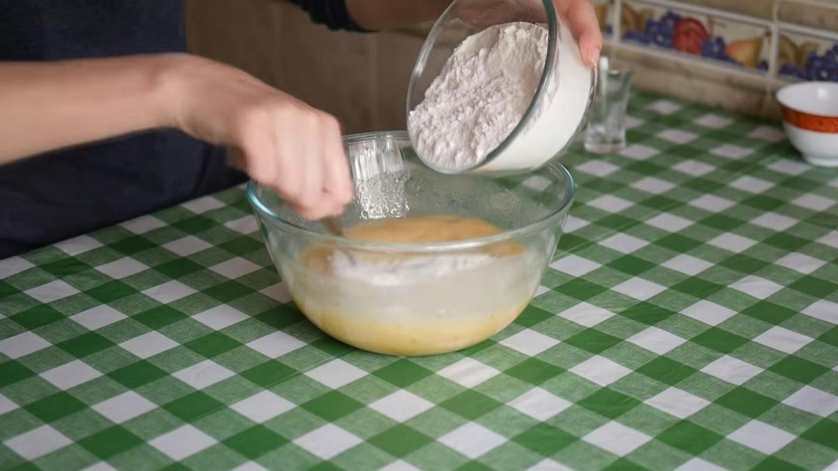 Муку из пиалы насыпают в миску с тестом