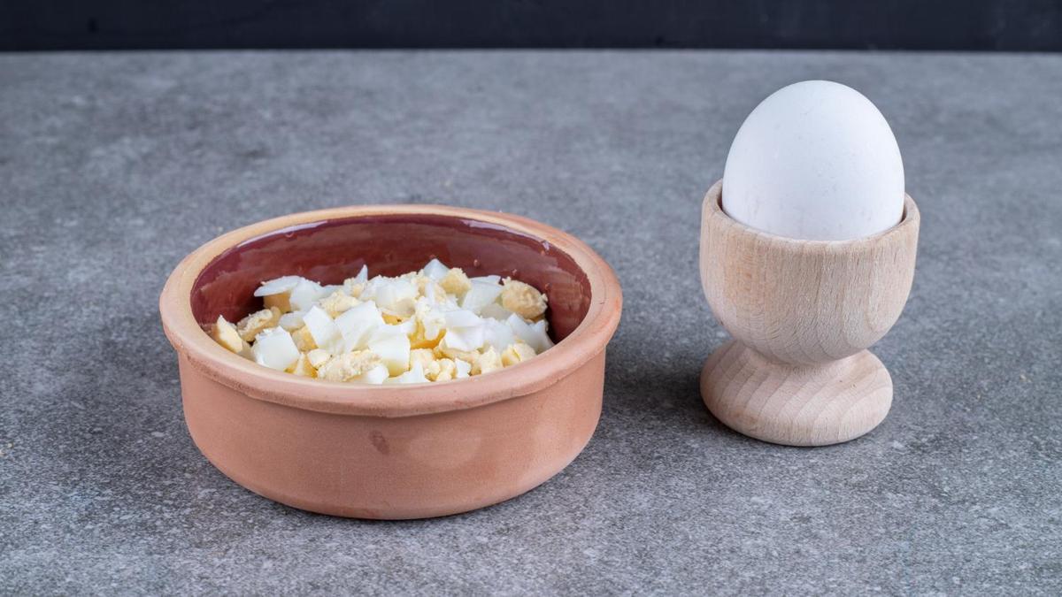 На столе сваренные яйцо целиком и нарезанное кубиком