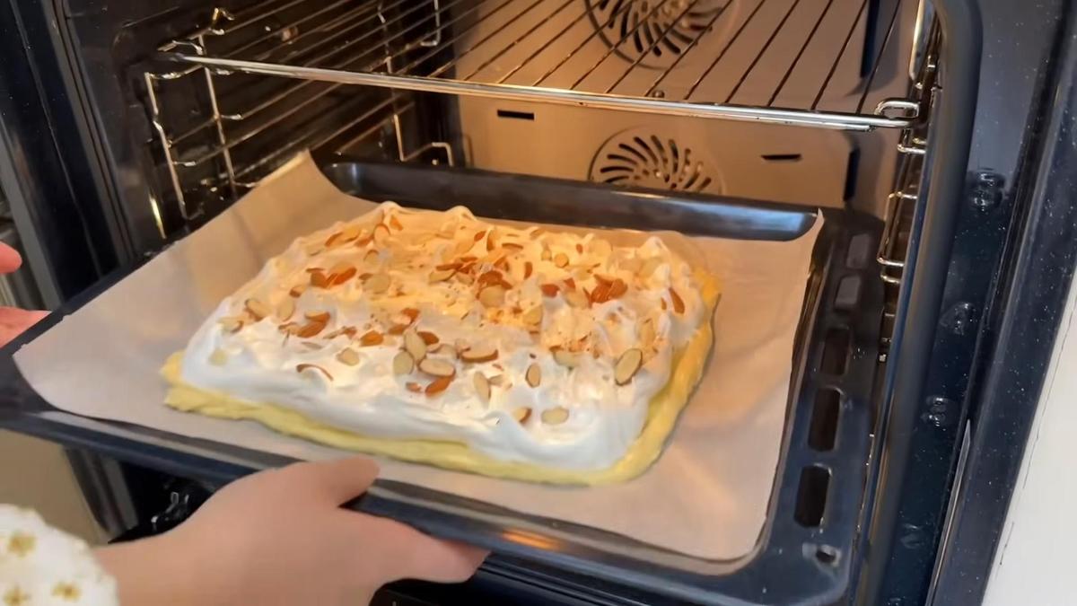 Противень с коржом из бисквита и меренги ставят в духовку