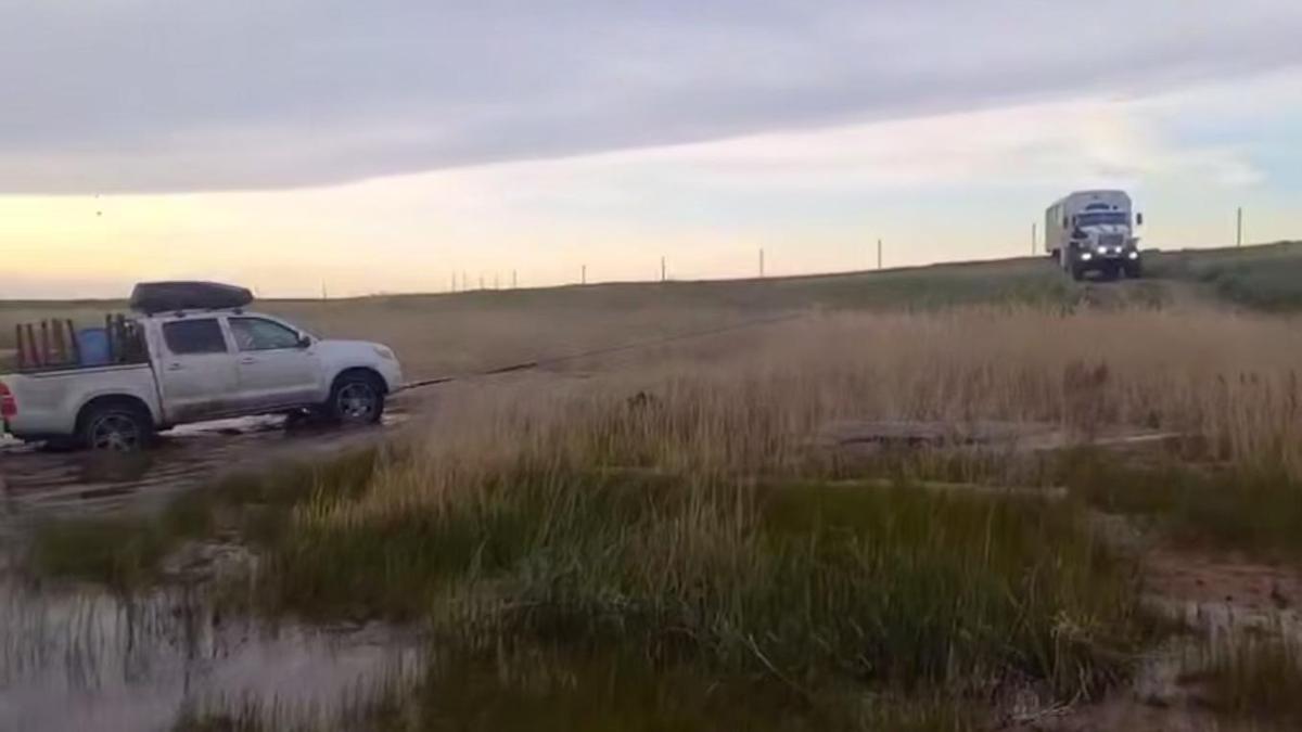 Спасатели вытаскивают автомобиль из грязи Спасатели вытаскивают автомобиль из грязи