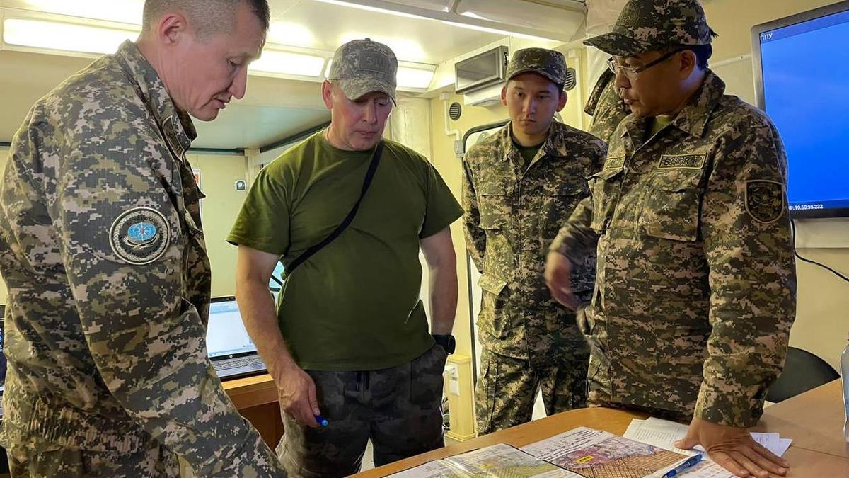 Представители МЧС в комнате возле стола с картами местности