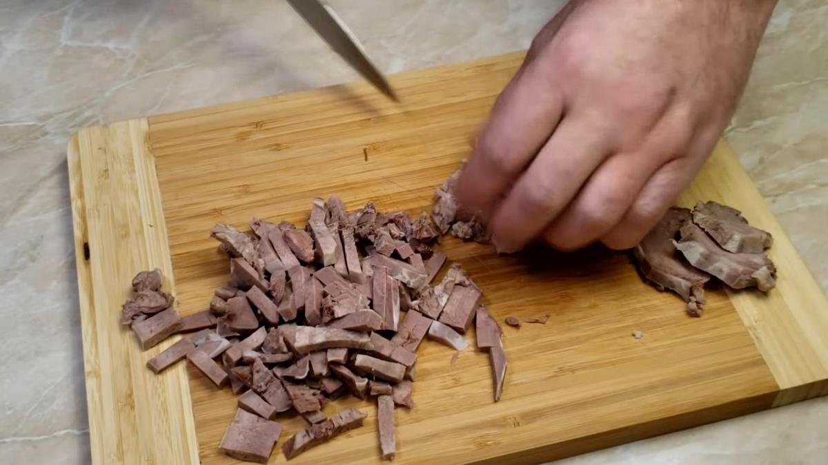 Язык нарезают соломкой на разделочной доске