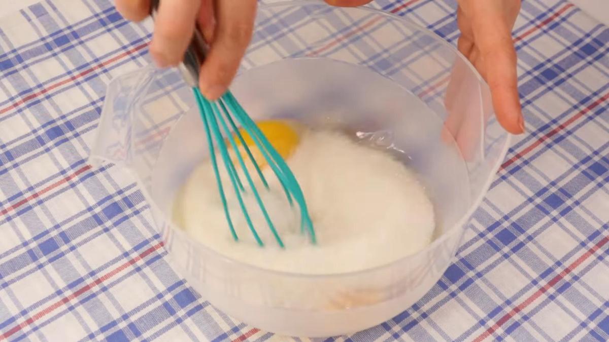 В пластиковой миске венчиком смешивают яйца с сахаром