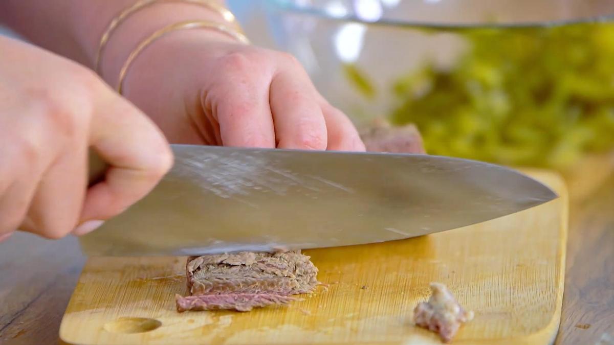 На разделочной доске нарезают отварную говядину