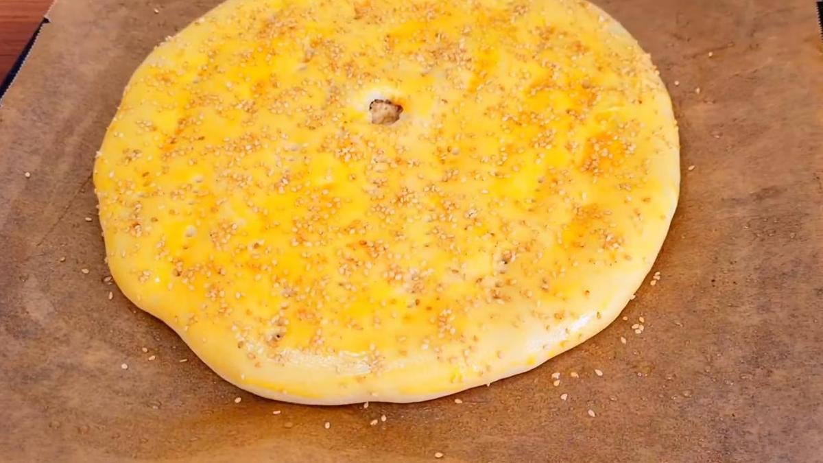 Пирог, смазанный желтком и посыпанный кунжутом