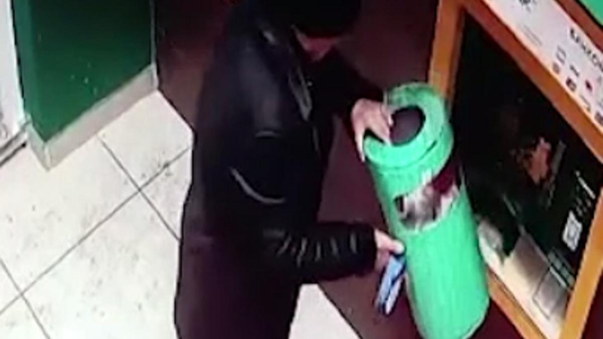 Мужчина с урной в руках возле банкоматов Мужчина с урной в руках возле банкоматов