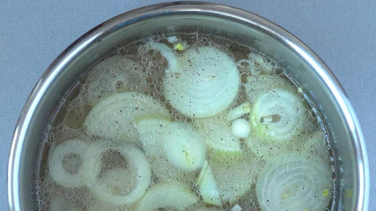 Нарезанный кольцами репчатый лук в курином бульоне
