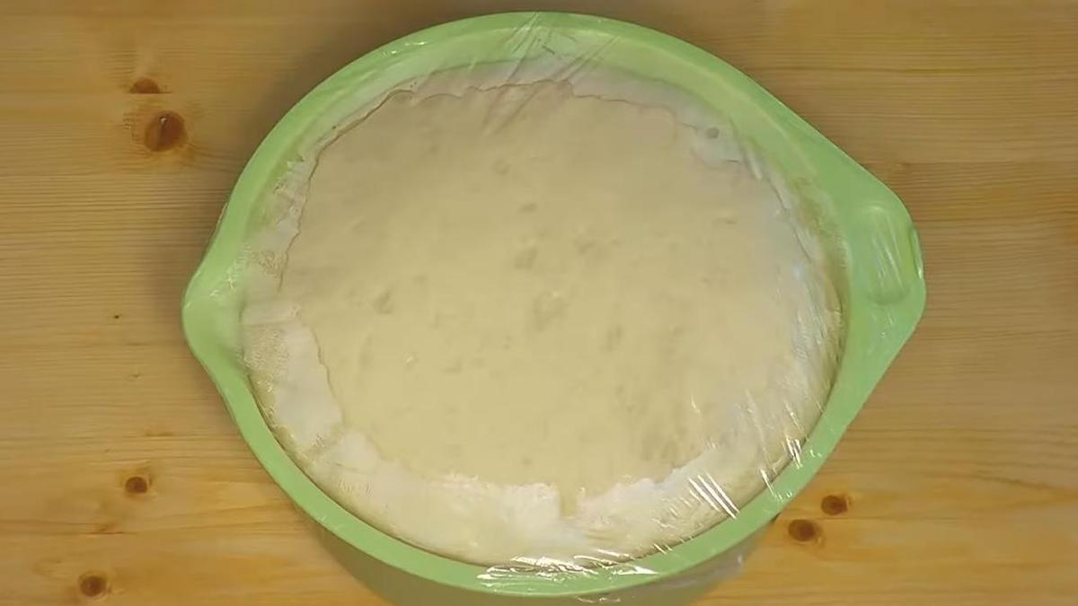 Тесто поднялось в миске под пленкой