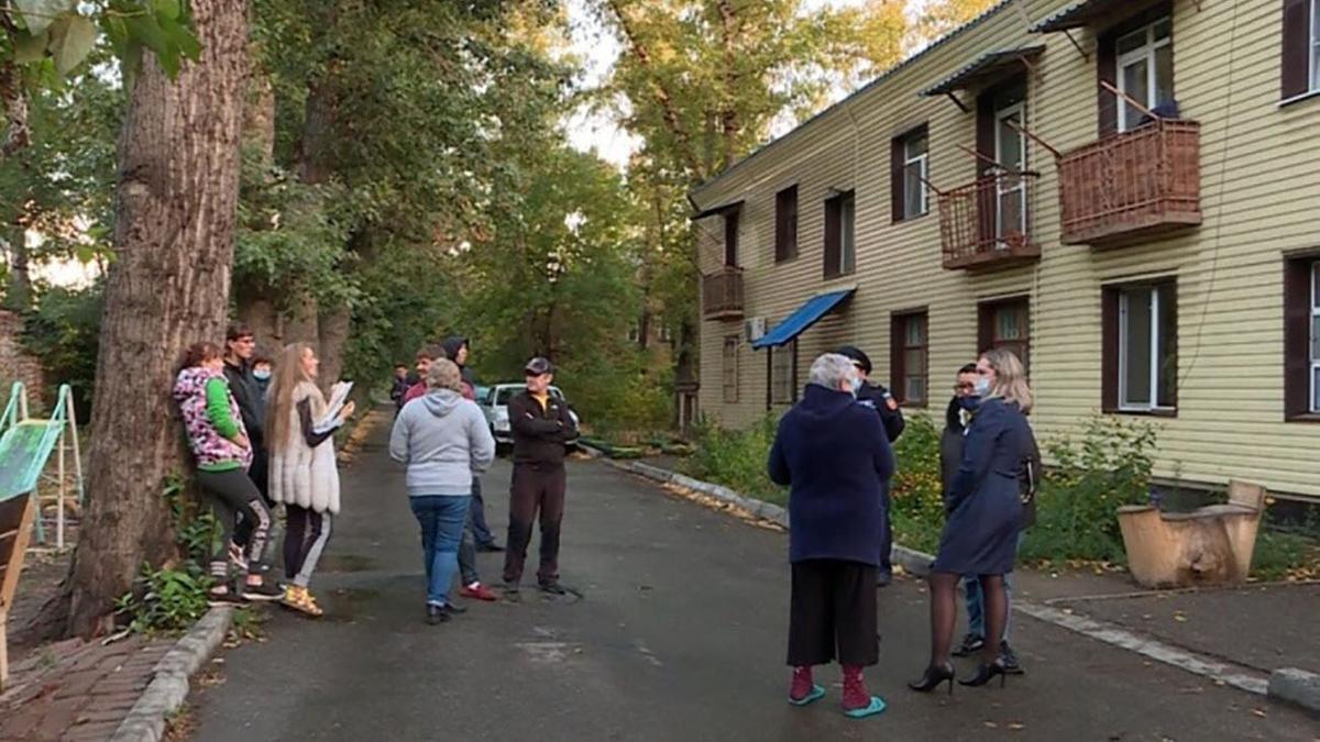 Люди стоят на улице перед домом в Усть-Каменогорске