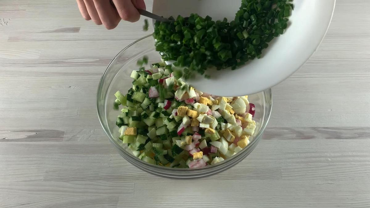 Добавление зеленого лука к ингредиентам окрошки