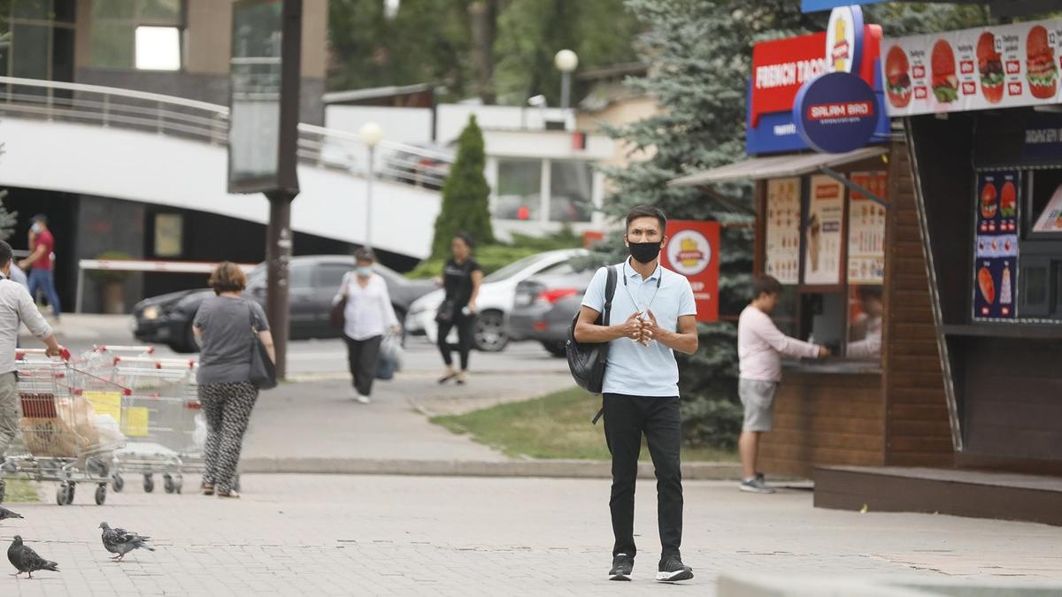 парень в маске стоит на улице