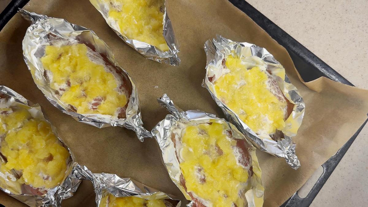 На противне лодочки из фольги, наполненные куриным филе и ананасом